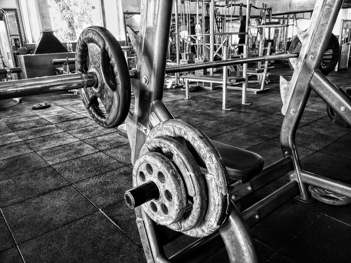 Loaded barbell resting on a bench press station
